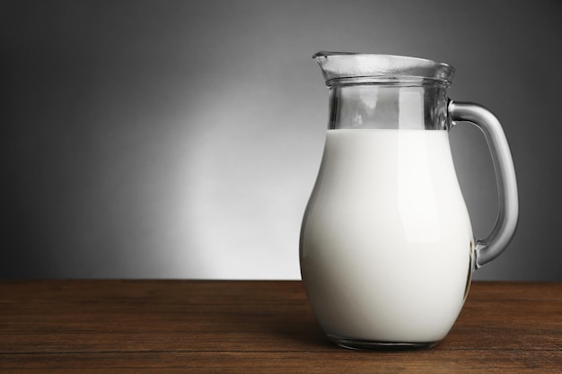 Glas Milch auf Holztisch auf dunklem Hintergrund