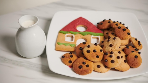 Glas Milch neben einem Teller mit zu Weihnachten gebackenen Lebkuchen