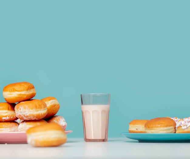 Glas Milch und Donuts an der blauen Wand