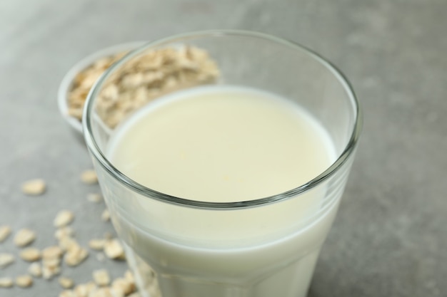 Glas Milch und Getreide auf grauem strukturiertem Hintergrund