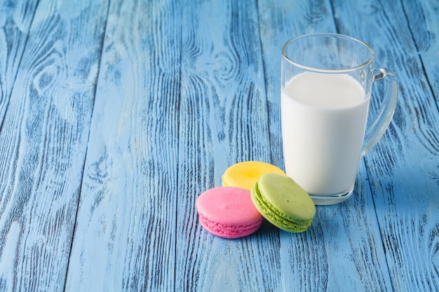 Glas Milch und Makrone auf Holztisch