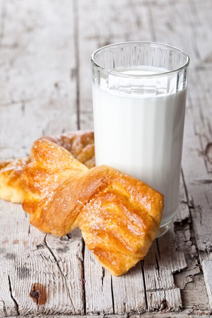 Glas Milch und zwei frische gebackene Brötchen