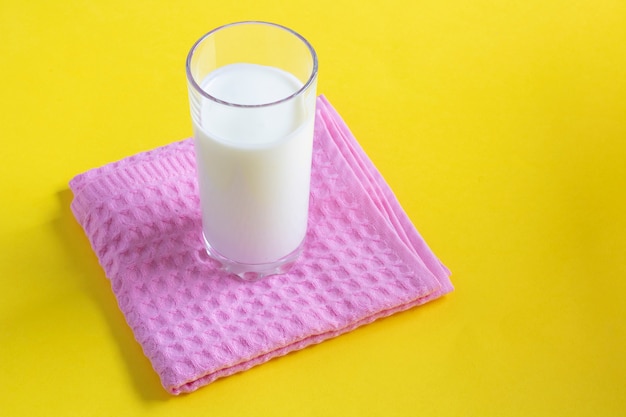 Glas Milch unter Handtuch auf gelbem Papier