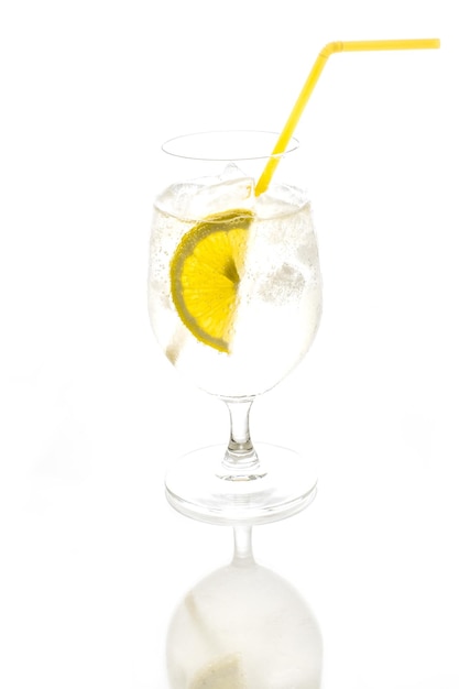 Glas Mineralwasser mit Zitronenscheiben in Nahaufnahme auf weißem Hintergrund