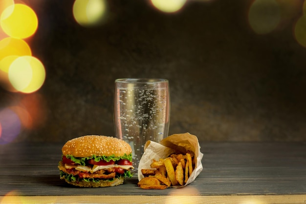 Glas Mineralwasser und Hamburger salzige Snacks Brezelchips