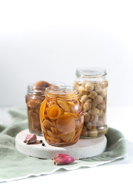 Glas mit Champignons in Dosen mit Knoblauch und Pfeffer.