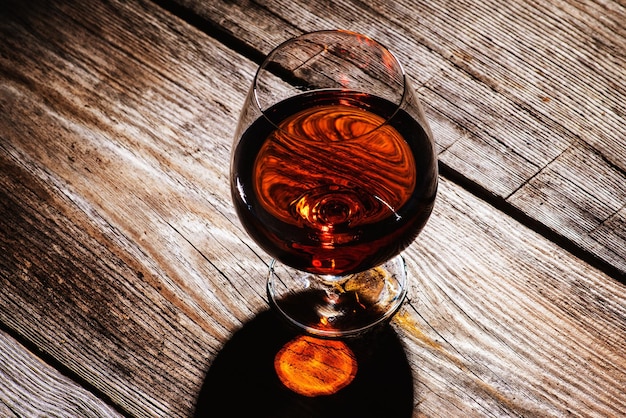 Glas mit Cognac auf Holzuntergrund