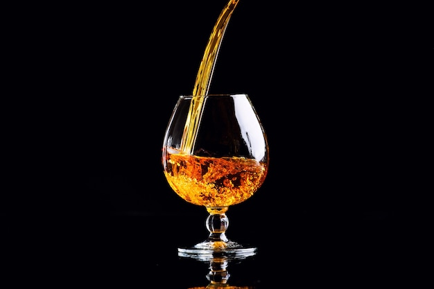 Glas mit Cognac auf Schwarz