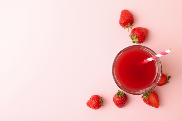 Glas mit frischem Erdbeersaft auf rosa