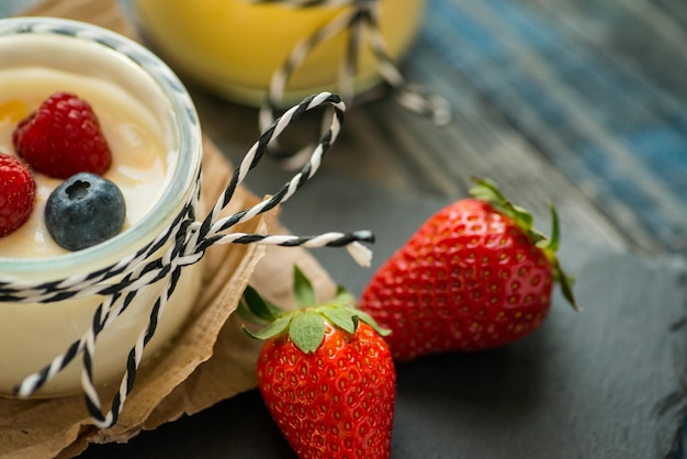 Glas mit frischem Joghurt auf einem rustikalen Tisch