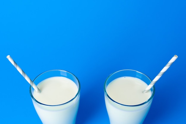 Glas mit frischer Milch gegen blaue Nahaufnahme