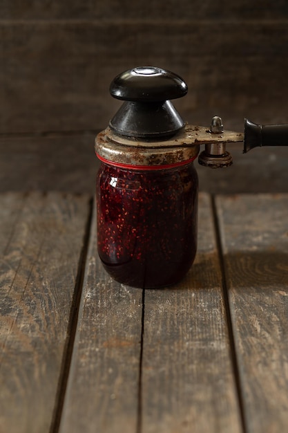 Foto glas mit himbeermarmelade auf holzbrettern näheres kochen