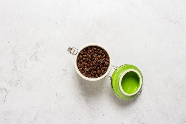 Glas mit Kaffeekörnern auf einem konkreten Hintergrund.