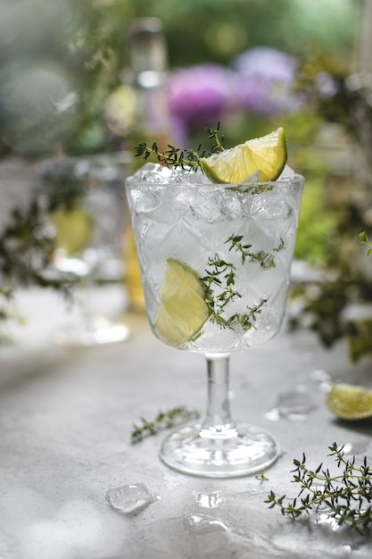 Glas mit kalt gefrorener erfrischender Limonade mit Limette und Thymian