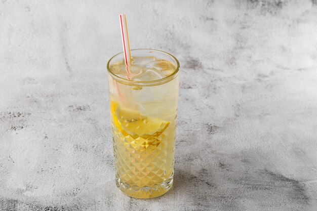 Glas mit Limonade mit Zitrone, kaltem Erfrischungsgetränk oder Getränk mit Eis auf hellem Marmorhintergrund. Draufsicht, Speicherplatz kopieren. Werbung für Cafe-Menü. Horizontales Foto.