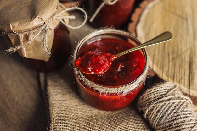 Glas mit Löffel und Pflaumenmarmelade mit Basteldekor