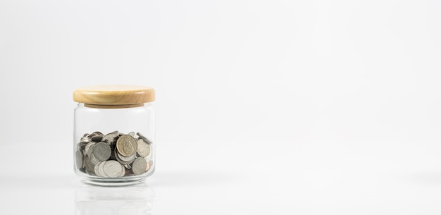 Glas mit Münzen auf weißem HintergrundJar of Money Isolated on a White Background