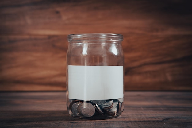 Glas mit Münzen und leerem Papier im Inneren