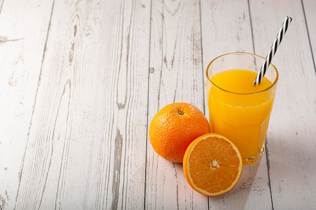 Glas mit Orangensaft auf dem Tisch.