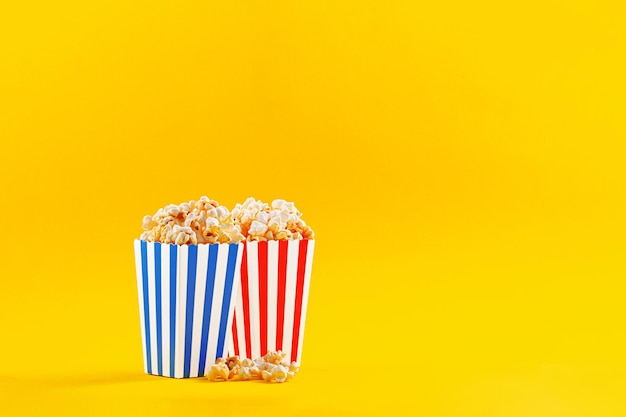 Glas mit Popcorn auf gelbem Hintergrund