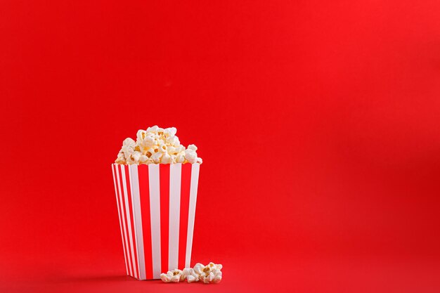 Glas mit Popcorn auf rotem Grund