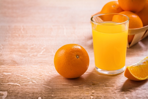 Glas mit Saft und Orangen