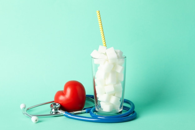 Glas mit Zuckerwürfeln, Herz und Stethoskop