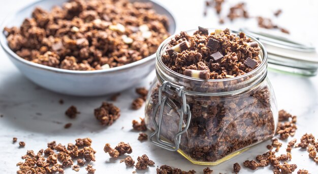 Glas Müsli mit dunklen und Milchkokoladenstücken - Nahaufnahme.