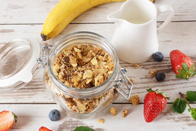 Glas Müsli mit frischen Beeren und Früchten auf weißem Holztisch Hintergrund Entgiftung