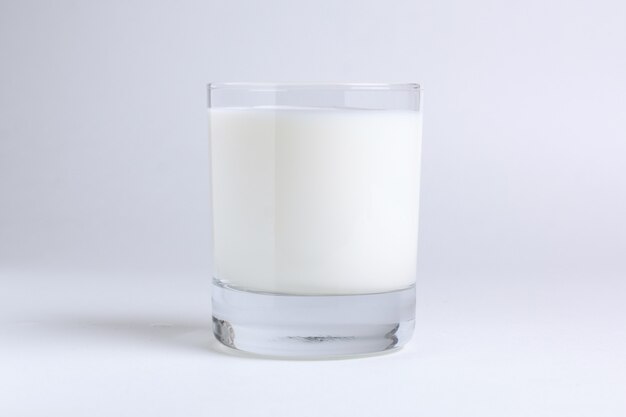 Glas natürliche gesunde Milch auf Weiß