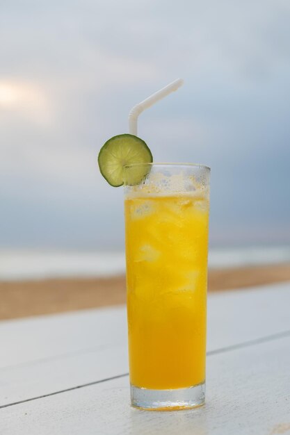 Glas Orange-Cocktail mit Limettenscheibe auf dem Tisch an der Strandbar