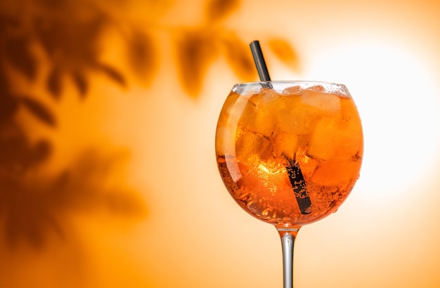 Glas Orangen-Aperol-Spritz-Cocktail auf defokussiertem Blatthintergrund