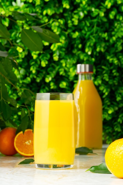 Glas Orangensaft und frischer tropischer Saft der Orangensaftflasche