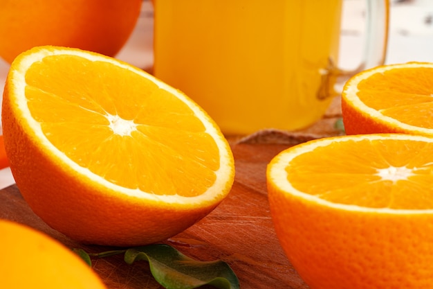 Glas Orangensaft und Orangen auf dem Tisch schneiden