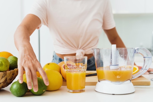 Glas Orangensaft und Zitruspresse auf dem Küchentisch