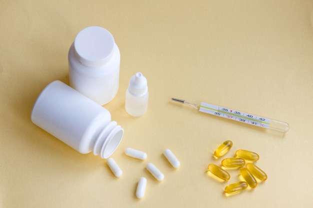 Glas Pillen Vitamine und ein Thermometer auf dem Tisch Medikamente Behandlung von Erkältungen und Grippe