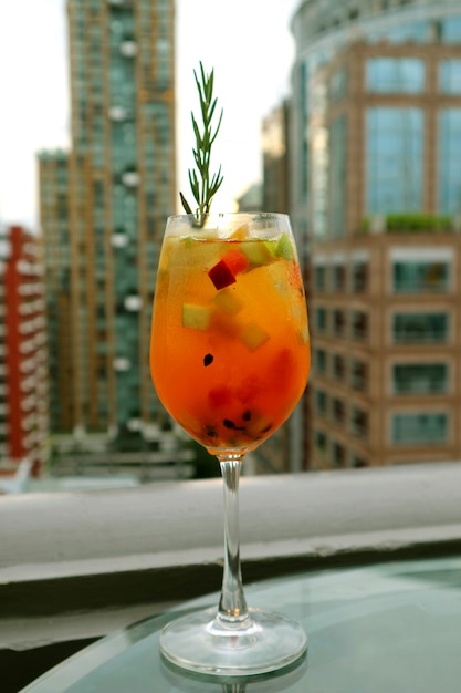 Foto glas sangria-cocktail mit frischen früchten auf der dachterrasse der bar