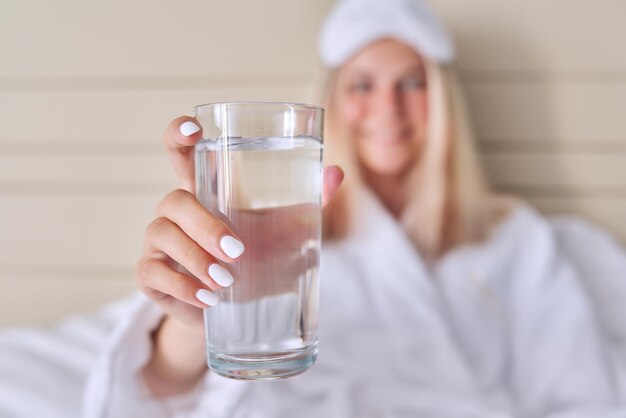 Glas sauberes Wasser Nahaufnahme in der Hand der jungen Frau