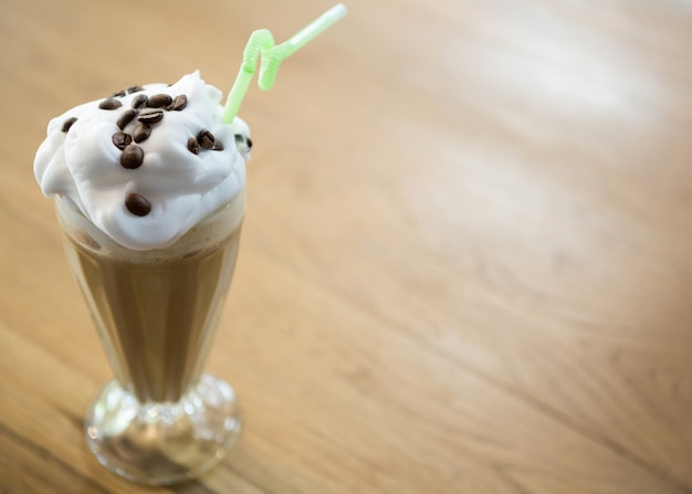 Glas Schokoladenmilchshake mit Sahne auf Holztisch im Café