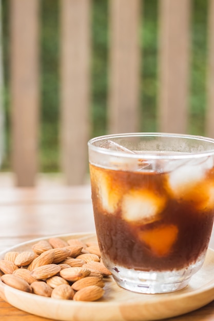 Glas schwarzer gefrorener Kaffee mit Mandelkorn