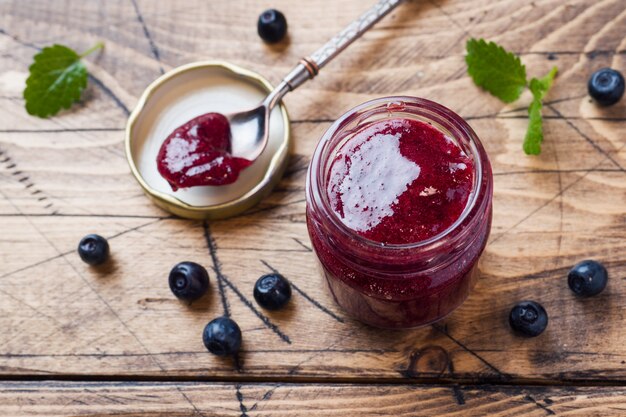 Glas selbst gemachte Blaubeermarmelade auf einer Holzoberfläche