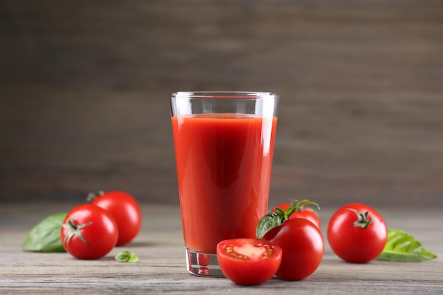 Glas Tomatensaft mit Gemüse auf hölzernem Hintergrund