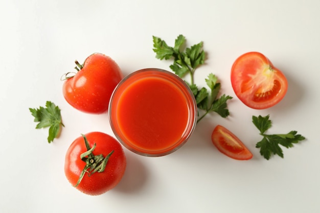 Glas Tomatensaft, Tomaten und Petersilie auf weißem Hintergrund