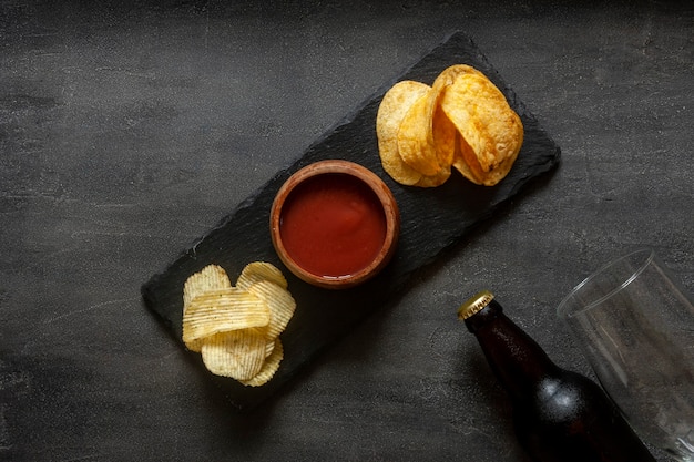 Glas und Flasche Bier mit Pommes und Tomatenketchup