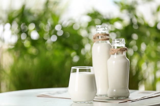 Foto glas und flaschen frische milch auf dem tisch im freien