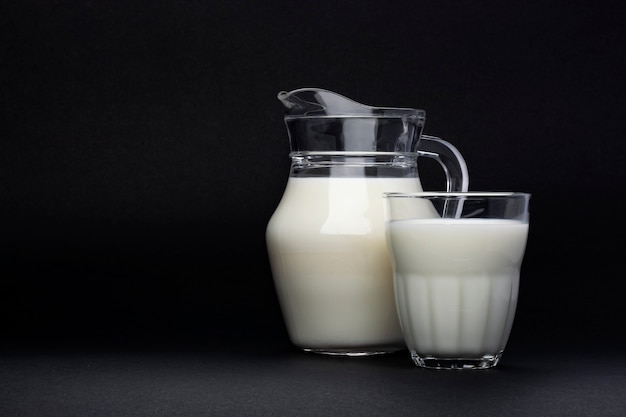 Glas und Glas Milch lokalisiert auf Schwarzem mit Kopienraum für Text, Milchproduktkonzept