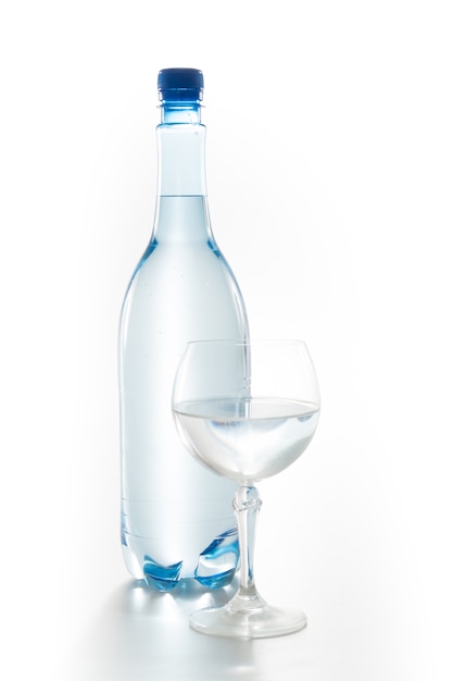 Glas Wasser mit einer Flasche lokalisiert auf Weiß