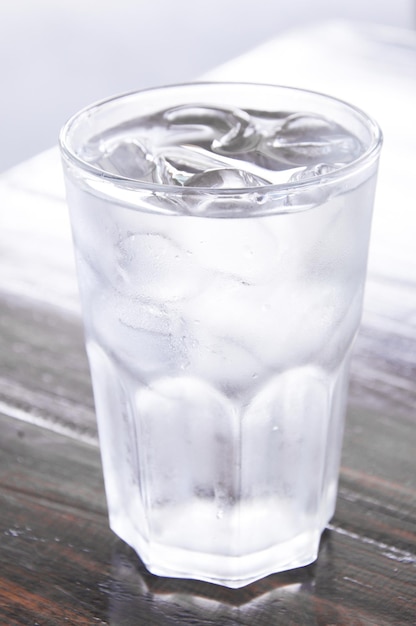 Glas Wasser mit Eis auf Holztisch, sauberes Wasser, Trinkwasser