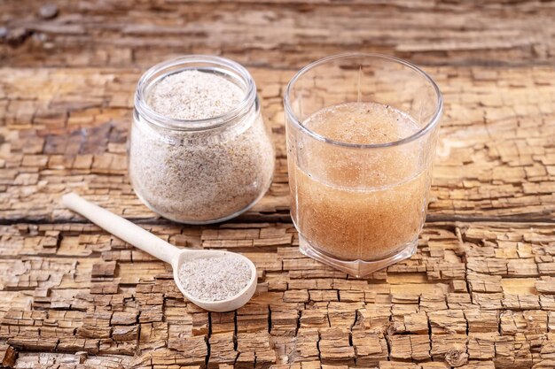 Glas Wasser und eine Kochbananenschale auf einem alten Holzbrett