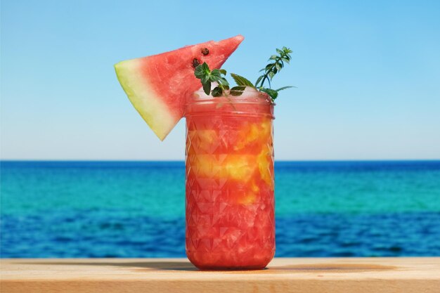 Glas Wassermelonen-Smoothie blaues Meer im Hintergrund